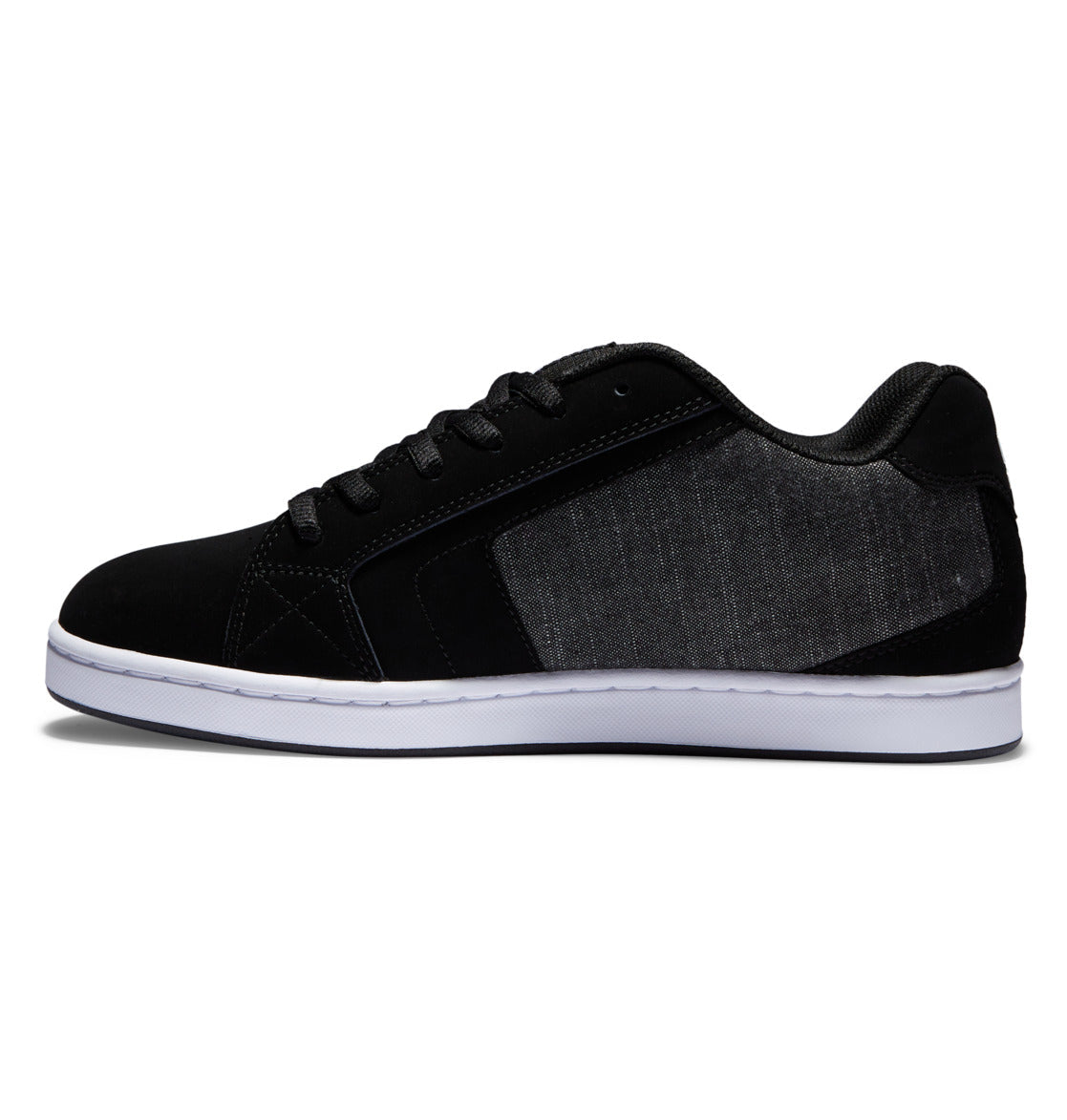 A left-side view of the DC Shoes Men’s Net sneaker, featuring a black low-top design with a white sole and a dark gray fabric side panel, constructed from durable materials.