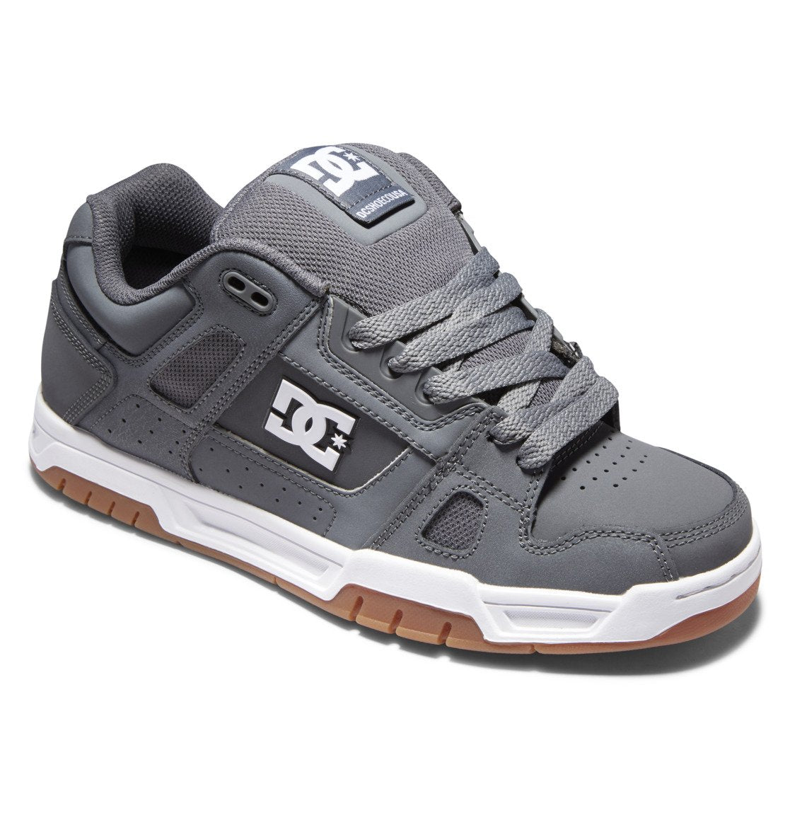 The DC Shoes Men’s Stag Shoes are gray skate shoes with a durable cupsole, featuring a white and brown sole, a white DC logo on the side, and gray laces. These shoes offer an oversized puff, padded tongue and collar for comfort and support.
