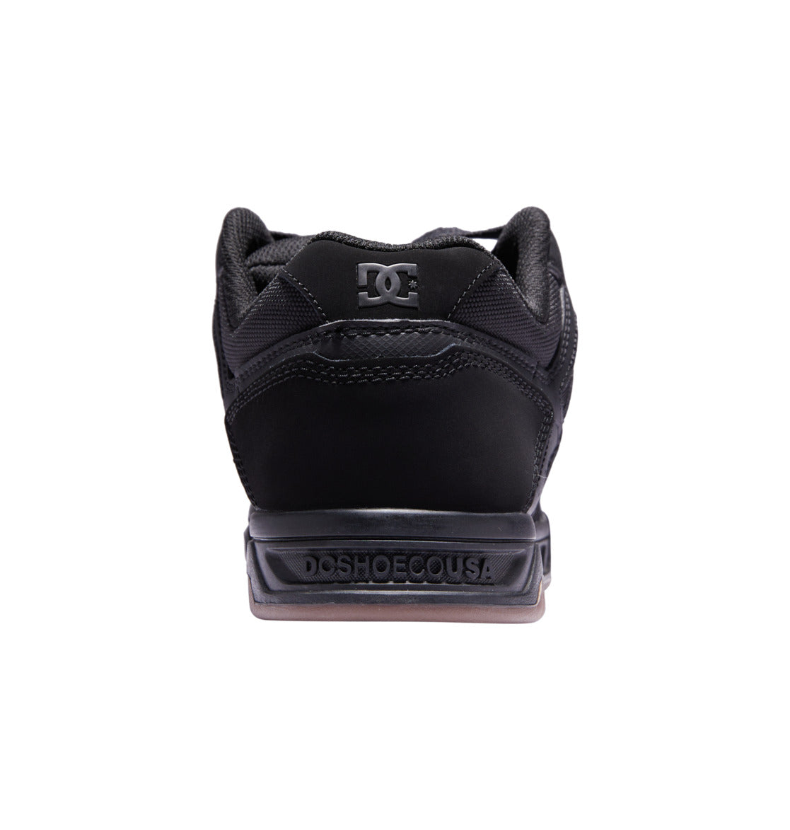 Back view of the DC Shoes Men’s Stag in black, with ‘DCSHOECOUSA’ embossed on the heel and the DC logo on the tongue, featuring an oversized puff and durable cupsole construction, shown against a white background.