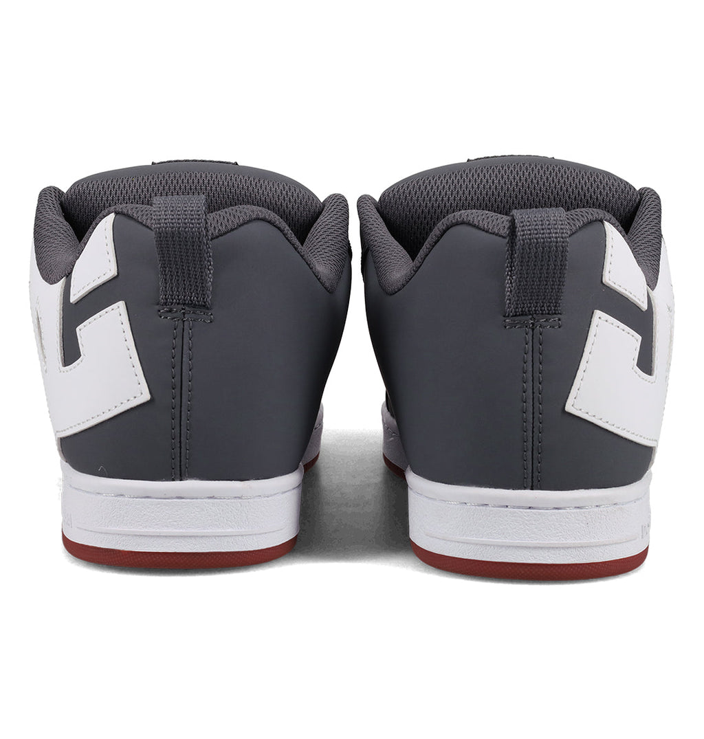 Back view of a pair of Men’s Court Graffik Shoes by DC Shoes in gray, featuring white accents, white midsoles, and red outsoles. The sneakers are placed side by side on a plain surface, highlighting their signature chunky skate style.