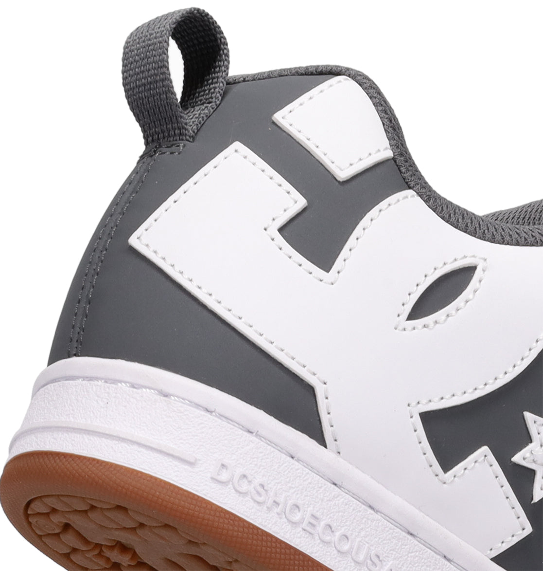 Here is a revised version of the sentence using your product data: Close-up of the heel of the Men’s Court Graffik Shoes by DC Shoes in gray and white, featuring a gum sole and highlighting the iconic DC Shoes logo on the side as well as the brand name embossed on the midsole—signature elements that exemplify these classic chunky skate shoes.