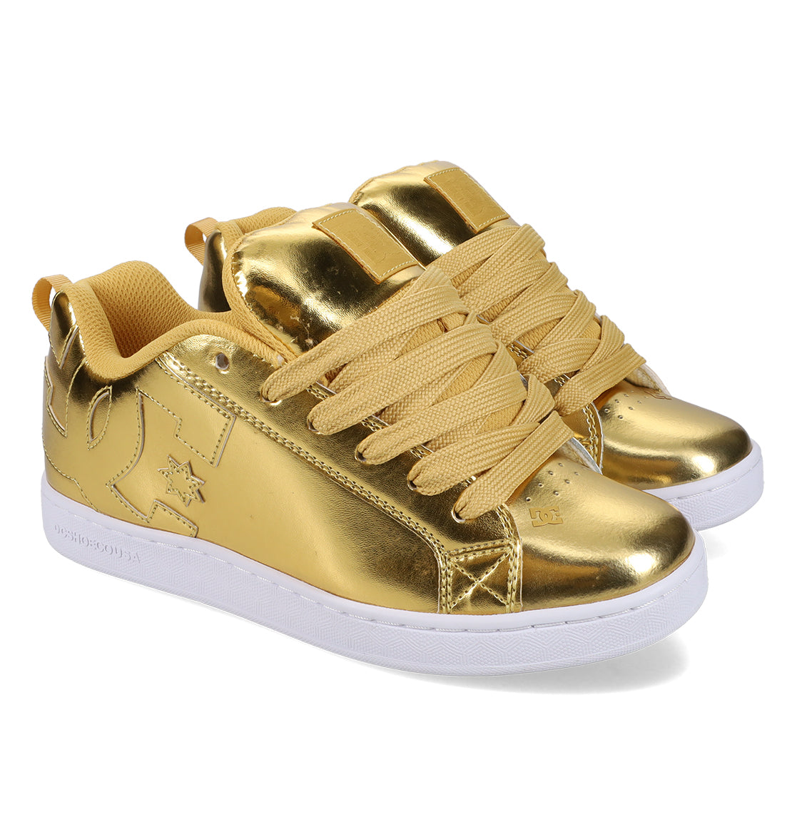 A pair of Women’s Court Graffik Shoes by DC Shoes in shiny gold, featuring thick gold laces and chunky white soles in a bold ‘90s-inspired design, displayed facing slightly to the left against a plain white background.