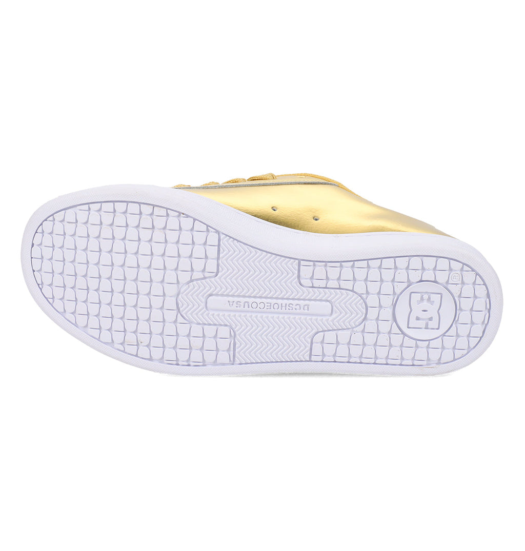 A gold Women’s Court Graffik Shoe from DC Shoes, shown from the bottom to highlight its white textured sole with a grid pattern and a circular logo on the heel—ideal for fans of chunky ‘90s-inspired women’s sneakers.