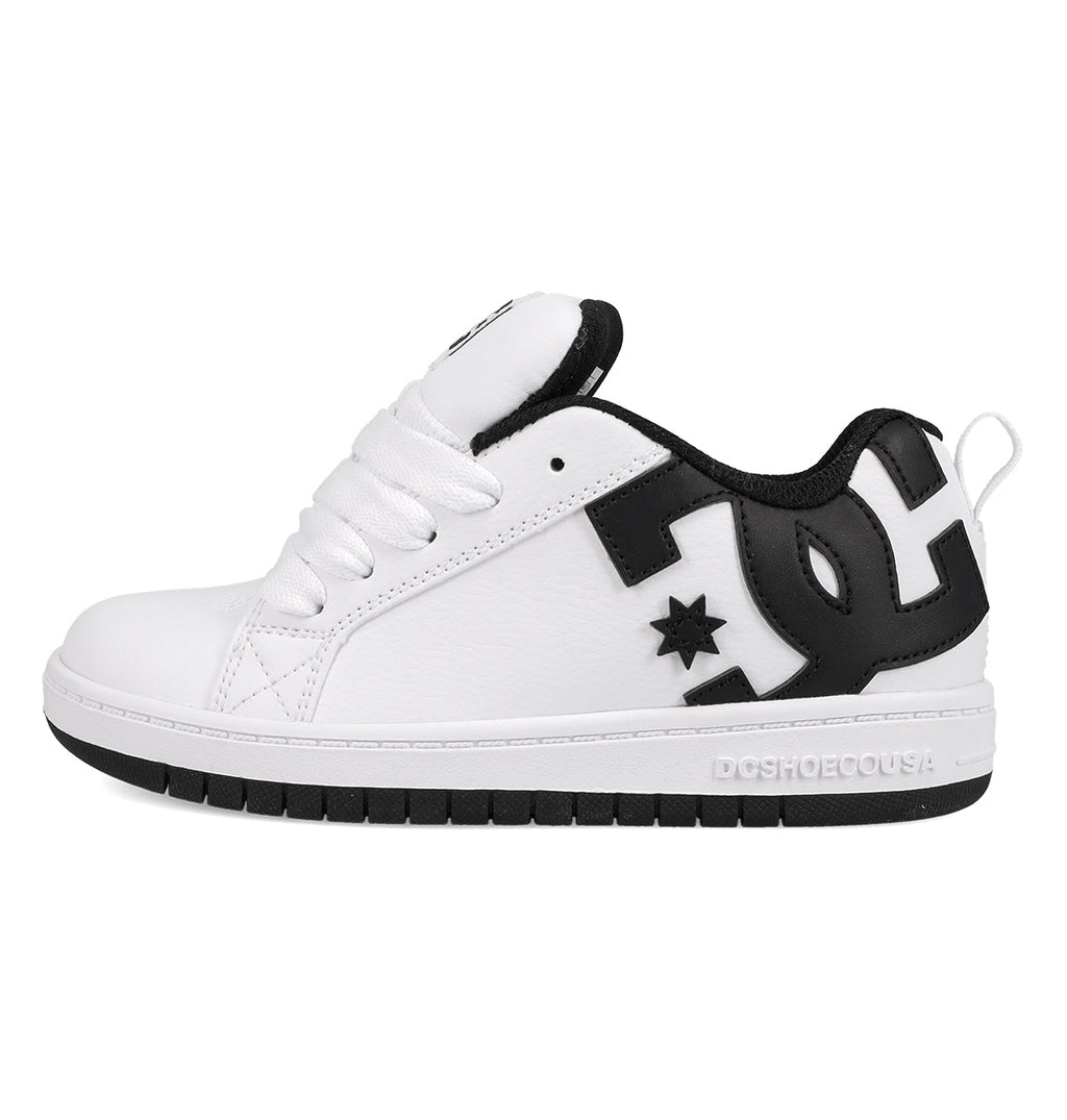 The DC Shoes Kids' Court Graffik Shoes feature a white low-top design with a thick sole, black heel and collar, bold black DC logo on the side, skate-inspired style, white laces, and subtle stitching details.