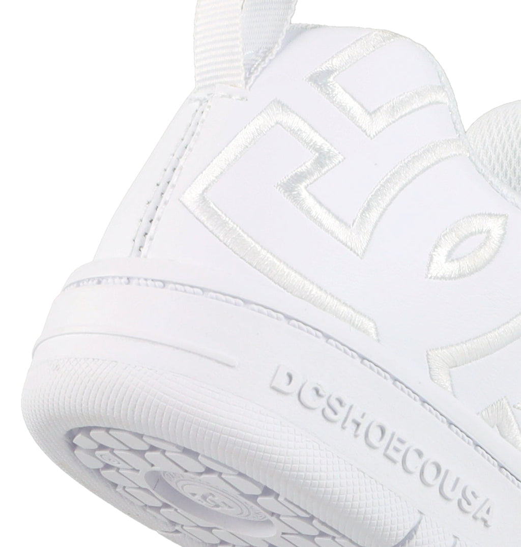 Close-up of the heel and side of DC Shoes Kids' Court Graffik Shoes, featuring raised white stitching in a stylized logo. The textured sole displays embossed DCSHOECOUSA text, highlighting their skate-inspired design for kids.