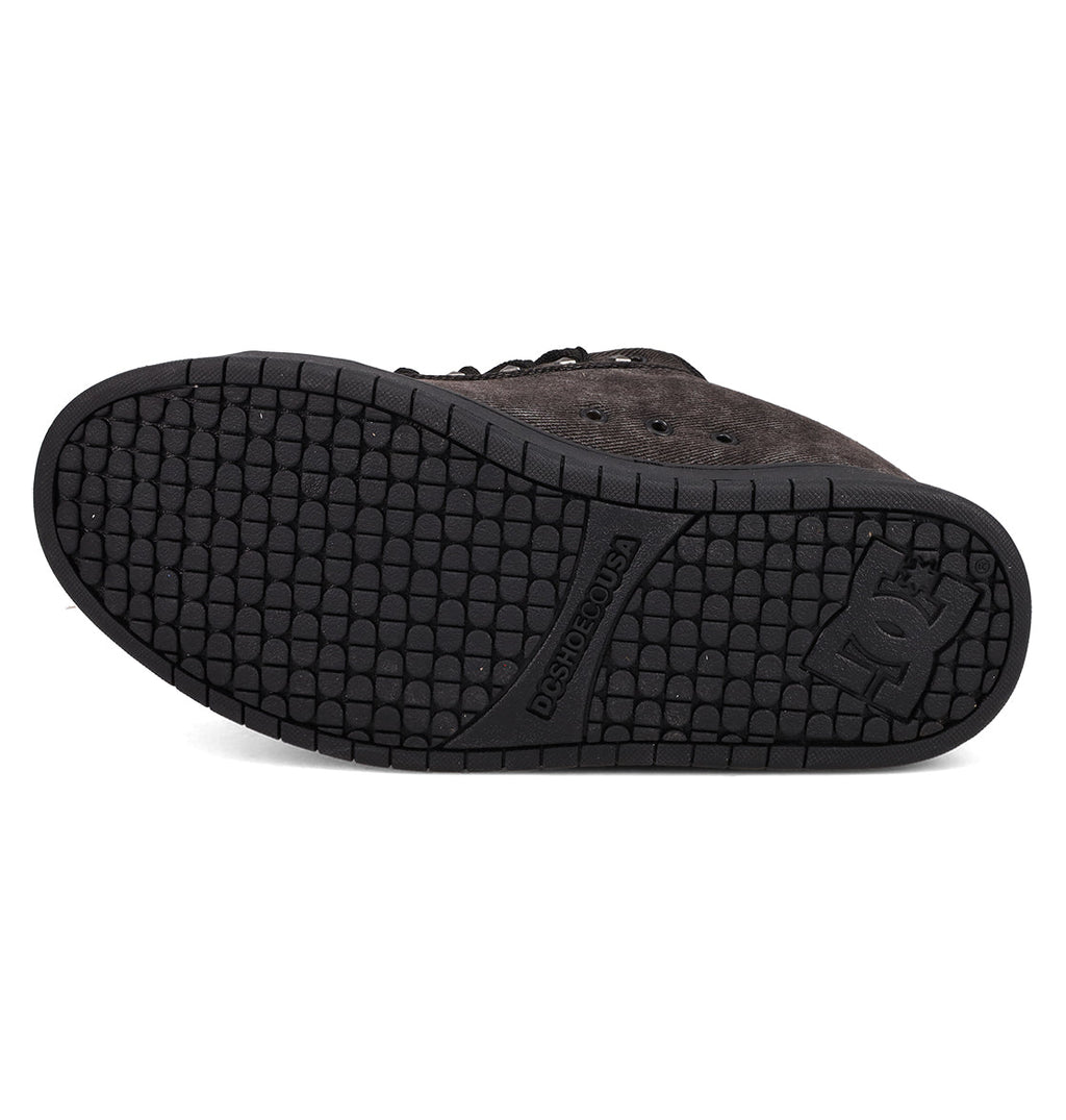 The image displays the bottom view of the Men's Court Graffik SE Shoes by DC Shoes, featuring a textured rubber sole with a DC logo and hexagonal grip pattern, complementing the sneaker's puffy design and stylish premium upper materials.