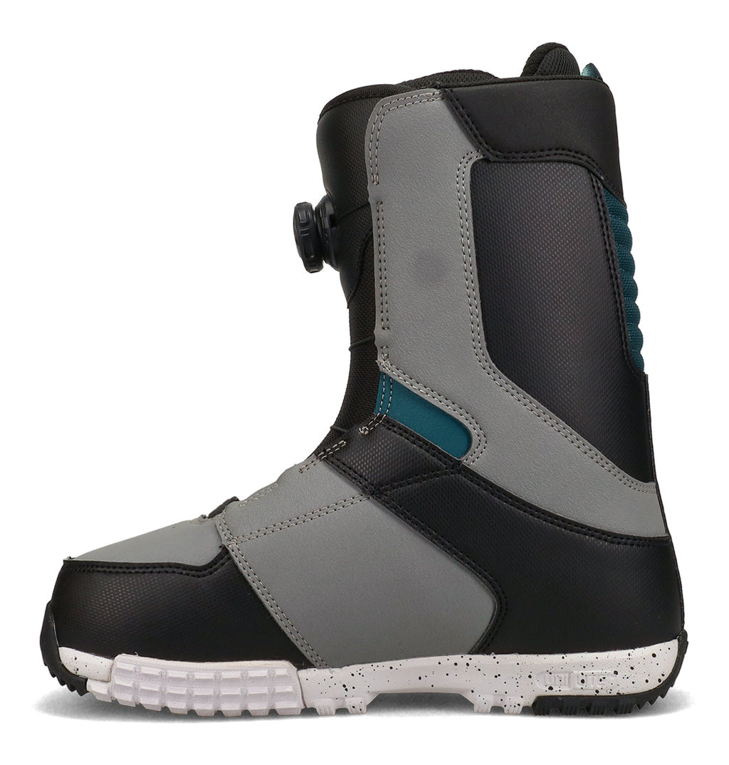 A gray and black snowboard boot from DC Shoes, the Men’s Control Snowboard Boots feature teal accents, a textured white sole, visible stitching, and a round tightening dial on the side. Shown in a side profile against a white background, these boots are designed for snowboarding enthusiasts.