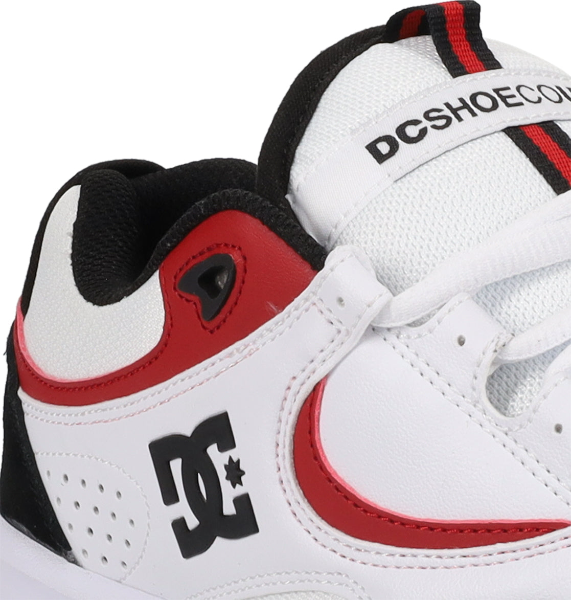 A close-up of the Men’s Kalynx Zero Shoes by DC Shoes in white, featuring red and black accents, highlights the iconic DC logo, detailed lace holes, and part of the tongue with DCSHOECO text—this model seamlessly combines style and performance for every skater.