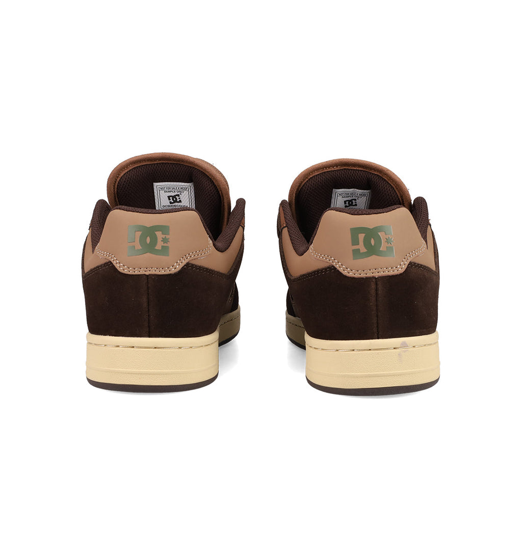 A pair of brown and tan Men's Manteca 4 Shoes by DC Shoes viewed from the back, featuring green DC logos on the heels and cream-colored soles—classic skate shoes with timeless style.