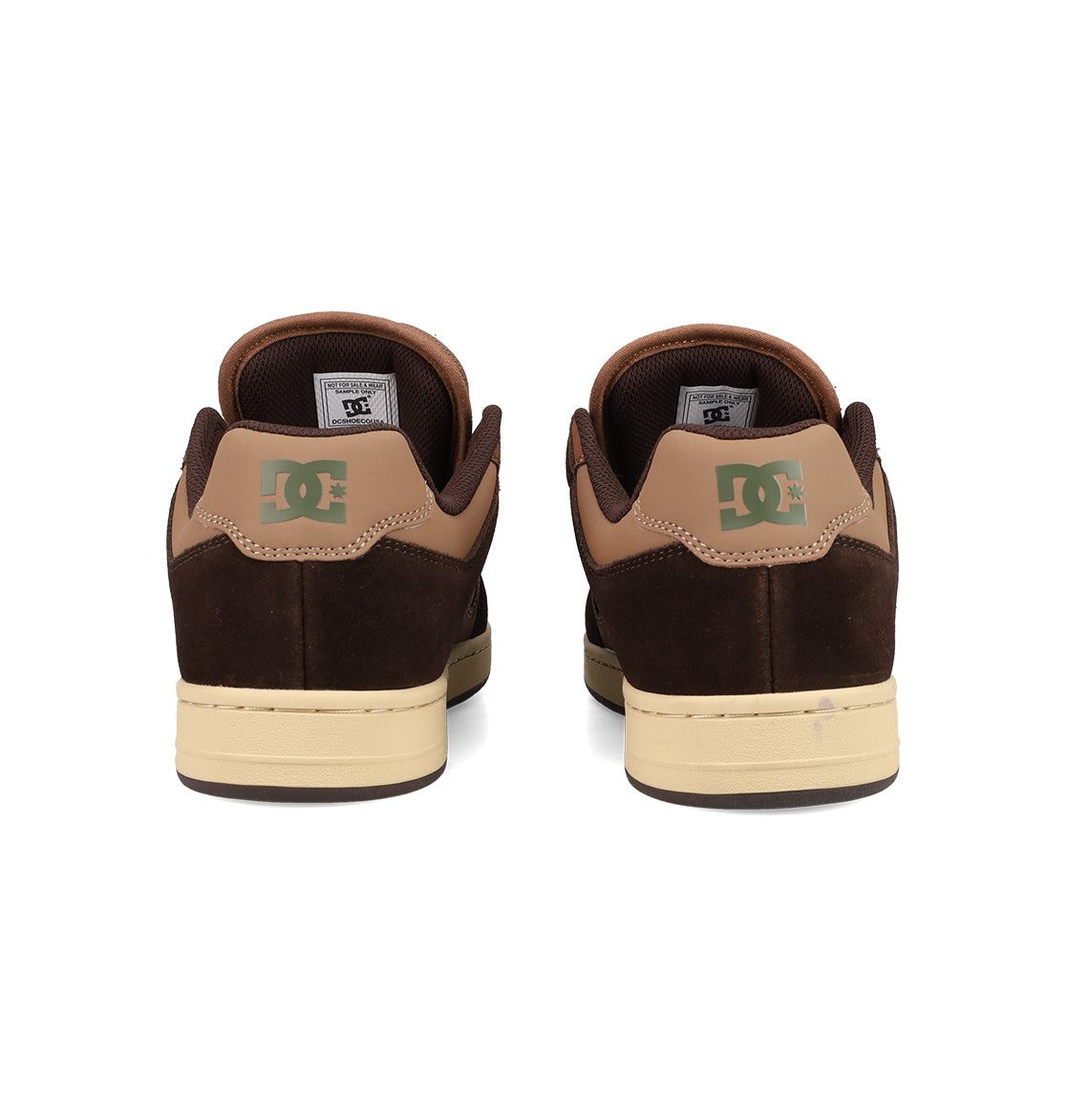 A pair of brown and tan Men's Manteca 4 Shoes by DC Shoes viewed from the back, featuring green DC logos on the heels and cream-colored soles—classic skate shoes with timeless style.