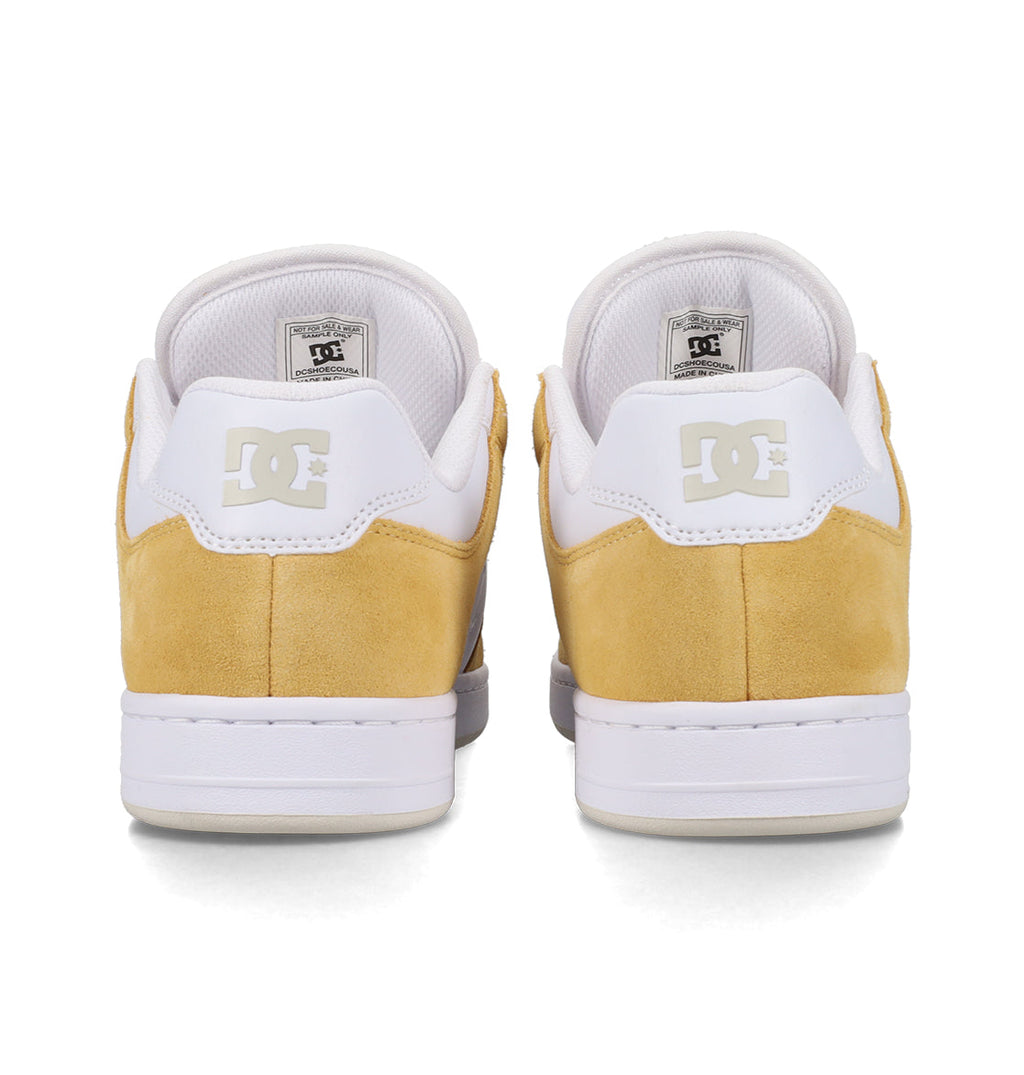 A pair of yellow and white DC Shoes Men’s Manteca 4 Shoes viewed from the back, featuring the DC logo on the heels and padded white collars—a classic example of DC Shoes’ performance-focused design.