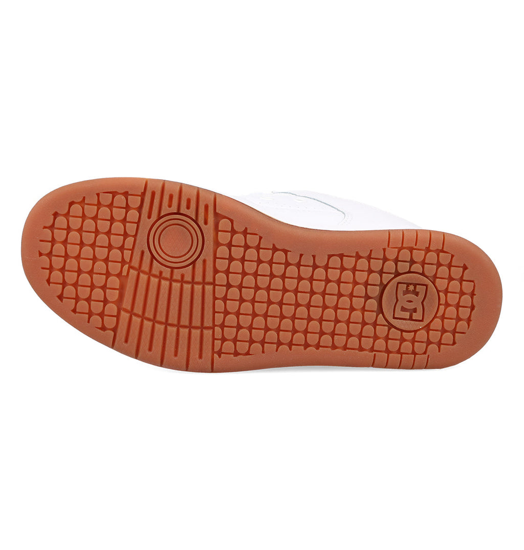 The image displays the gum rubber sole of the Women’s Manteca 4 Shoes by DC Shoes, highlighting a textured hexagonal pattern and two circular designs—one showcasing a stylized K—reflecting DC Shoes’ commitment to performance-focused design.