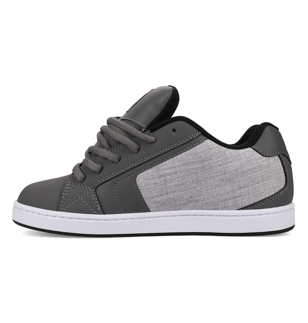 The Men’s Net Shoes by DC Shoes are shown in a side profile on a white background, featuring a gray colorway with black accents, gray laces, and a light gray fabric panel on the side crafted from durable materials, all set atop a white sole.