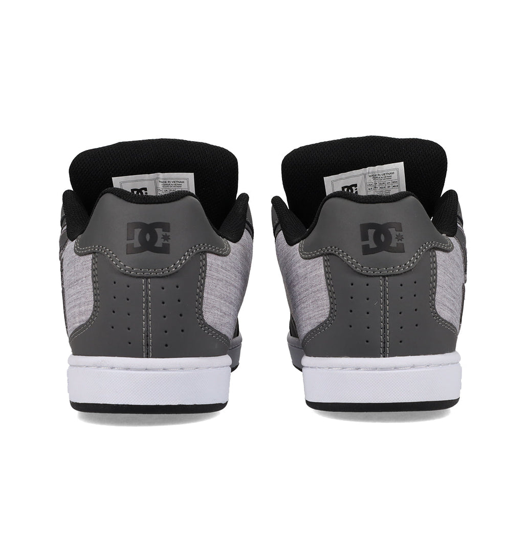 A pair of gray and black Men’s Net Shoes by DC Shoes is shown from the back, highlighting the white soles and the iconic DC logo on each heel. Crafted with durable fabrics, these puffy sneakers deliver both style and comfort.