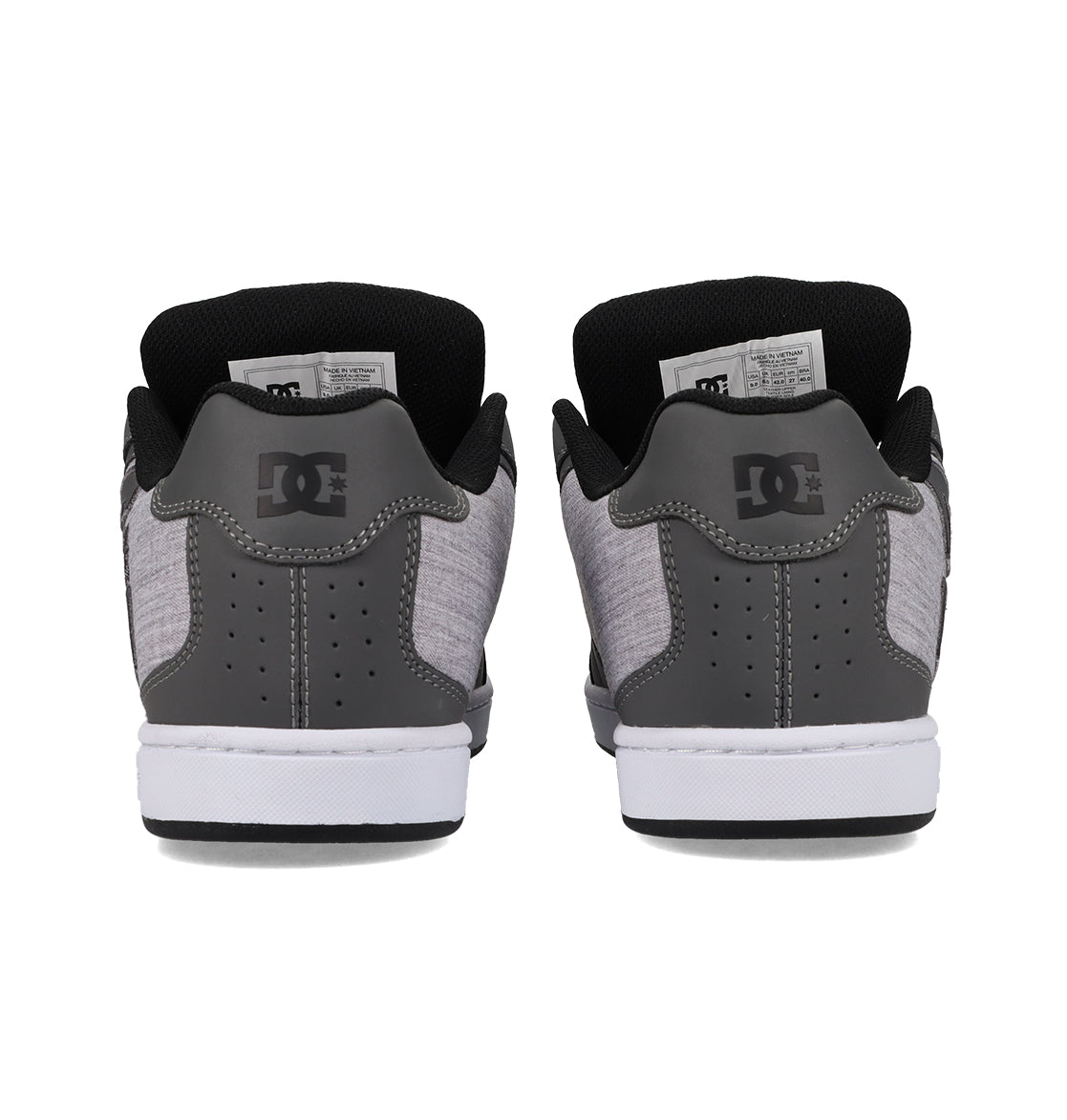 A pair of gray and black Men’s Net Shoes by DC Shoes is shown from the back, highlighting the white soles and the iconic DC logo on each heel. Crafted with durable fabrics, these puffy sneakers deliver both style and comfort.