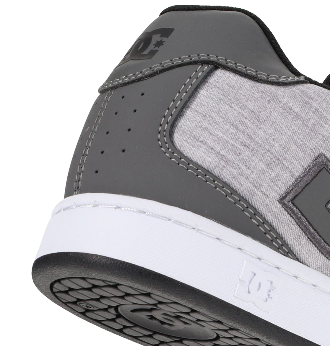 Close-up of the heel and side of a gray and light gray DC Shoes Men’s Net Shoe with a white sole, crafted from durable materials and featuring the DC Shoes logo on the side as well as embossed on the back of the midsole.