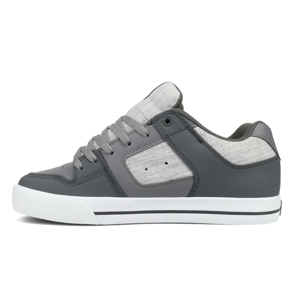 The DC Shoes Men’s Pure Shoes, shown in a side profile view, feature a gray and white low-top design with gray laces, a white sole, and light gray fabric accents on the sides and tongue—offering versatile style and all-day comfort.