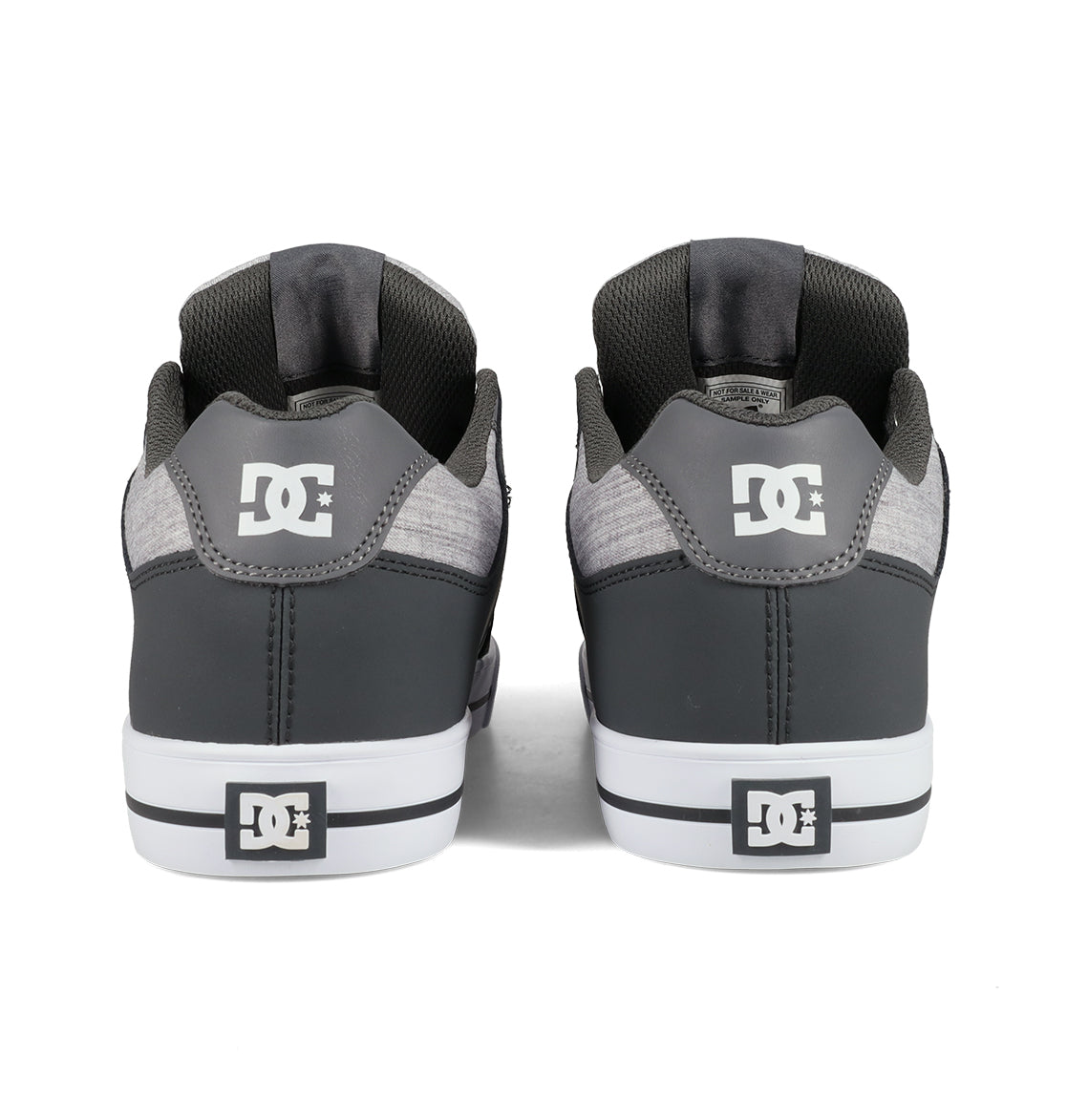 A pair of DC Shoes Men’s Pure Shoes in gray are shown from the back, featuring white DC logos on the heels and soles, along with white midsoles and black detailing—these comfortable sneakers are a versatile choice for any casual outfit.