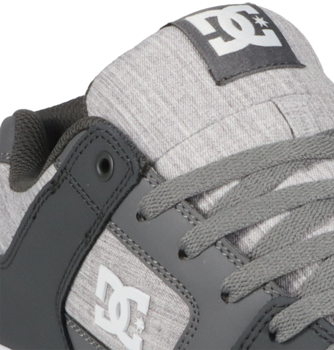 Close-up of a gray and black Men’s Pure Shoe by DC Shoes, highlighting the laces, logo patch on the tongue, and side branding. The textured fabric upper and smooth overlay accents showcase these versatile shoes designed for both style and comfort.