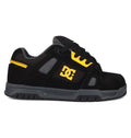 The DC Shoes Men's Stag features a black and grey design with yellow accents, a yellow side DC logo, black laces, and a durable cupsole. Styled for skate culture, it's displayed in side profile against a white background.