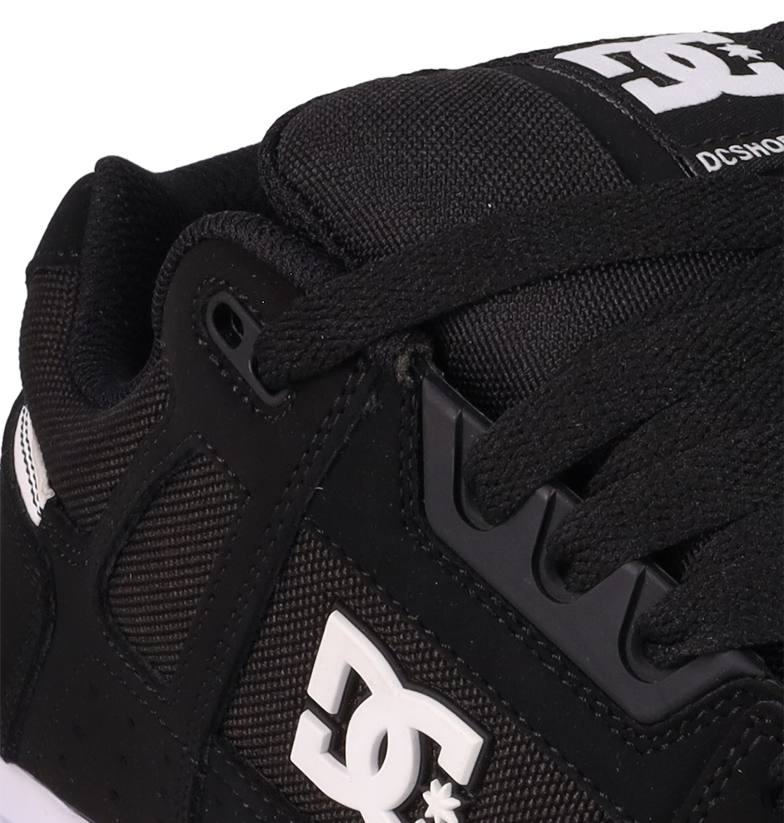 Close-up of the Men's Stag Shoes by DC Shoes in black, featuring visible laces, mesh and leather textures, cupsole construction, and a white DC Shoes logo on the side—ideal for skate culture enthusiasts.