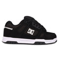 The Men's Stag Shoes by DC Shoes are shown in side profile against a white background, featuring a black upper with a white side logo, black laces, and a thick white and black cupsole—ideal for skate culture enthusiasts.