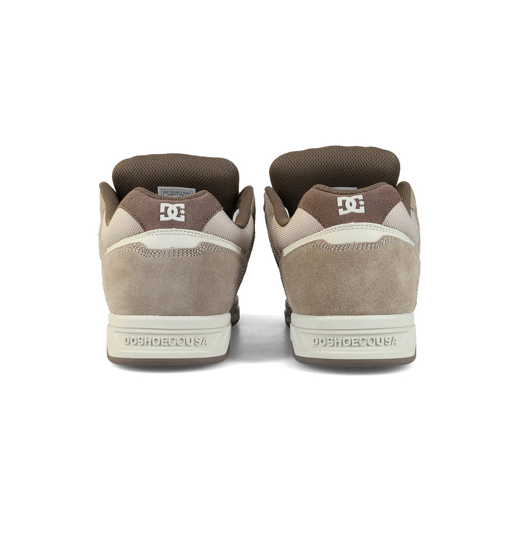 The Men's Stag Shoes by DC Shoes are shown from the back in brown and beige, featuring suede and mesh uppers, a durable cupsole, DC branding on heel and tongue, oversized puff accents, and padded collars.
