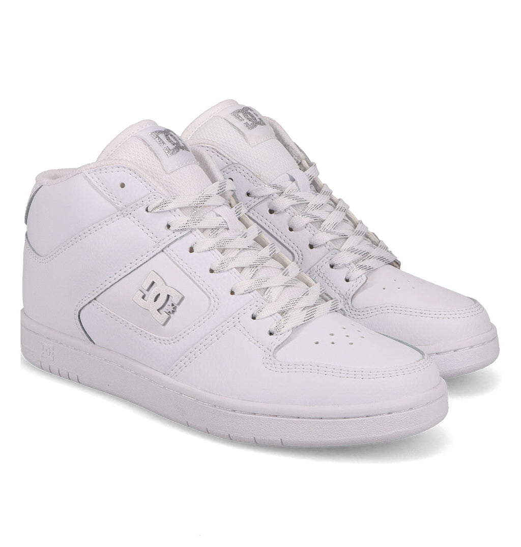 A pair of Women’s Manteca 4 Hi High-Top Shoes by DC Shoes, featuring a crisp white colorway with laces, side logo detailing, and perforated toe areas, are positioned side by side on a plain white background to highlight DC Shoes’ renowned performance-focused design.