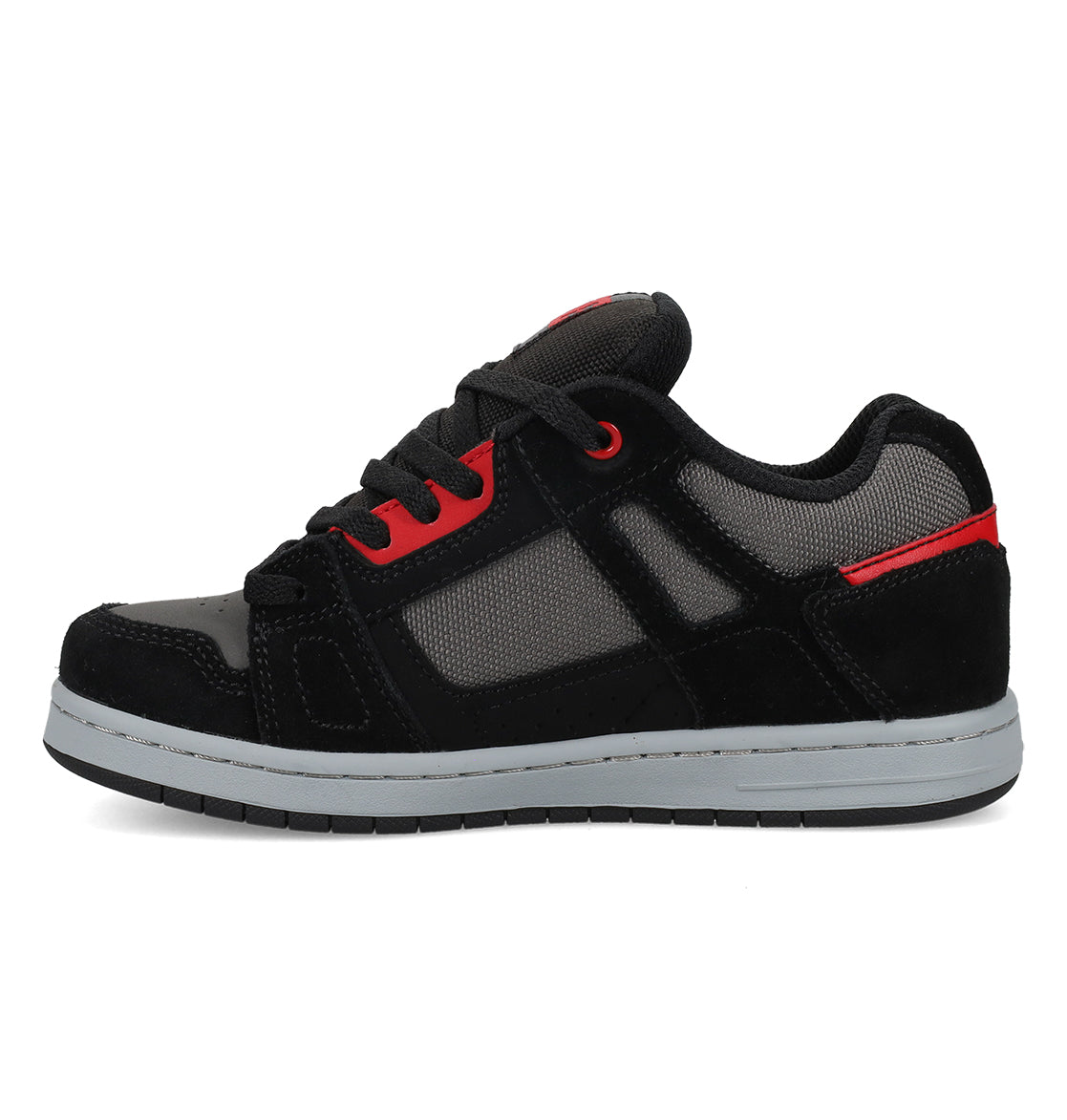 The Kids’ Stag Shoes by DC Shoes feature a black and gray design with red accents, a white rubber sole for enhanced impact absorption and lightweight cushioning, and black laces. They are displayed in a side profile on a white background.