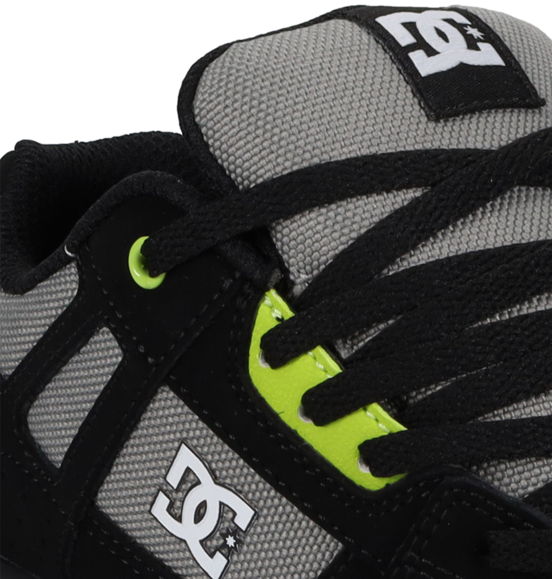 Close-up of the DC Shoes Kids’ Stag Shoes in gray and black, showcasing black laces, neon green eyelets, and the white DC Shoes logo on the side and tongue—a versatile everyday vulc sneaker with a minimal silhouette.