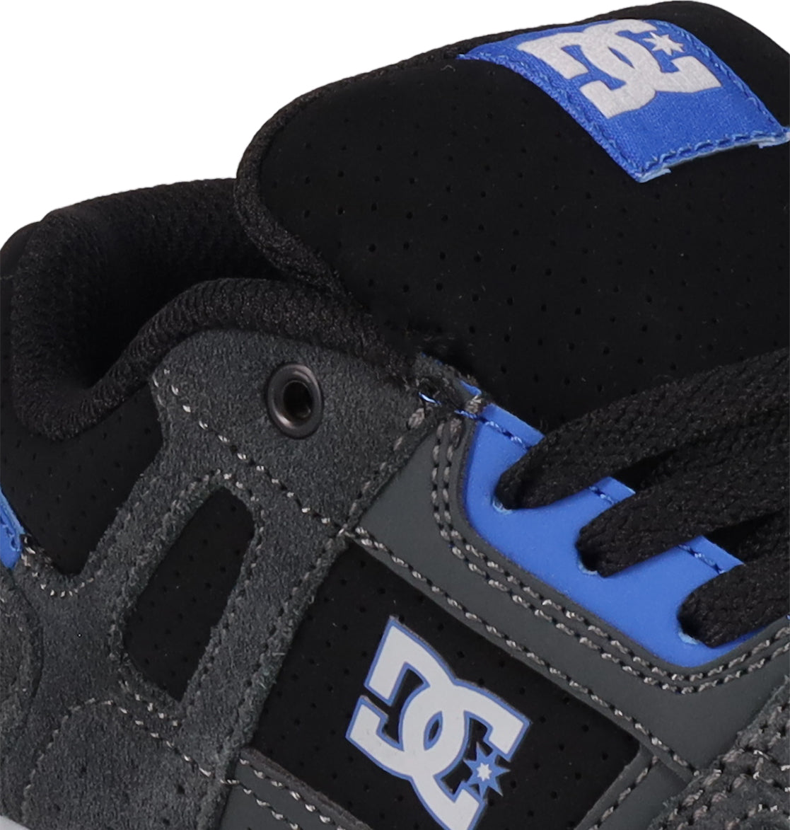 Close-up of DC Shoes Kids' Stag skate shoe in black, gray, and blue, with cupsole construction, black laces, perforated tongue detailing, and DC logo on the tongue and side.
