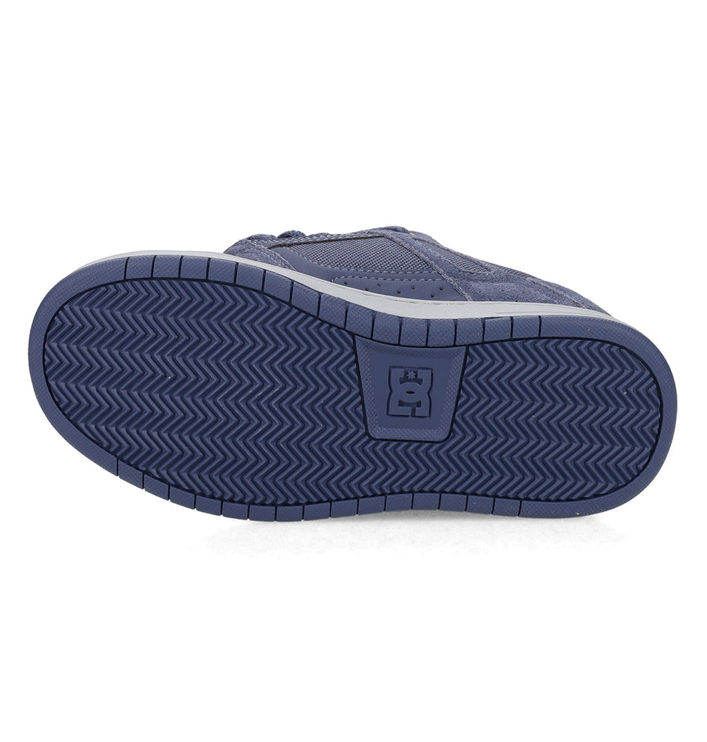 The DC Shoes Kids’ Stag Shoes feature a navy blue sole with a herringbone tread pattern and a rectangular logo at the center, designed as an everyday go-to vulcanized shoe with a minimal silhouette.