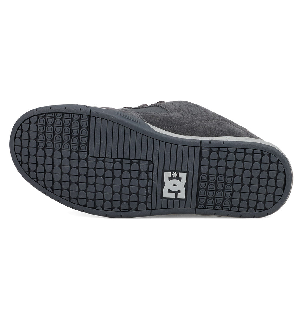 The image displays the black rubber sole of the Men's DC Command Shoes by DC Shoes, featuring a grid tread pattern and a white DC logo at the center, highlighting its skate-inspired, street-ready style.