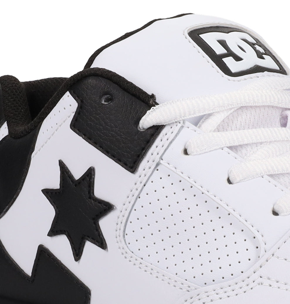 Close-up of the Men’s Command Shoes from DC Shoes, featuring a white and black colorway with a star-shaped black patch, perforated details, white laces, and the signature DC logo on the tongue—highlighting the classic bulky silhouette and future-ready comfort inspired by the iconic DC Command.