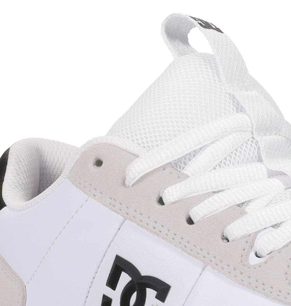 Close-up of the DC Shoes Men’s Astrix Shoe in white, featuring mesh fabric, white laces, a beige suede accent, and a black DC logo on the side. The image highlights the upper portion and part of the tongue, showcasing features tailored for optimal board control in street skateboarding.
