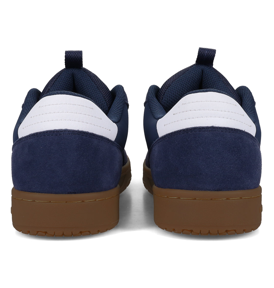 A pair of Men’s Astrix Shoes by DC Shoes in navy and white, featuring low-top suede heel panels and convenient pull tabs, are shown from the back with gum soles—ideal for street skateboarding and delivering excellent board control.