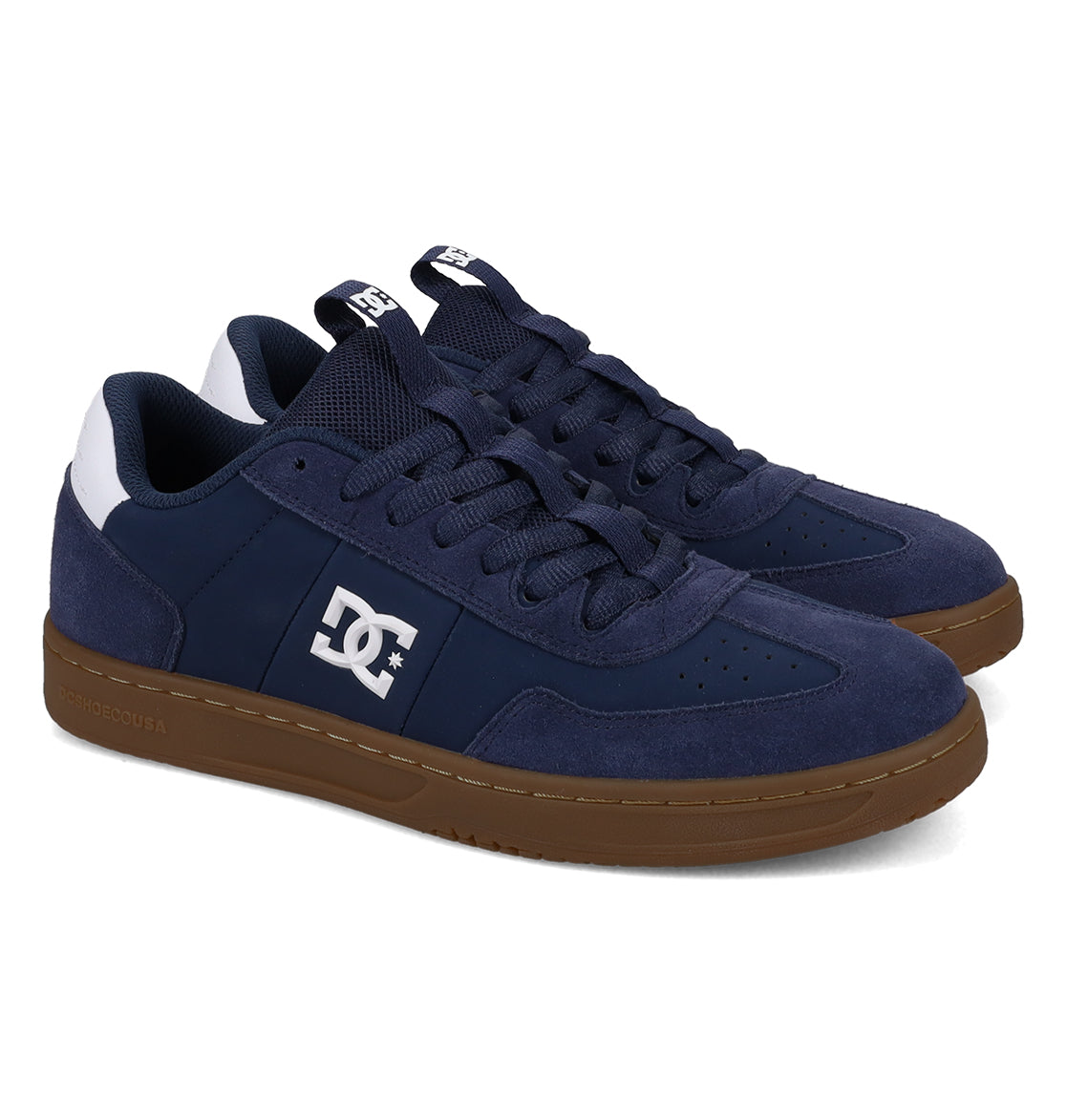 A pair of DC Shoes Men’s Astrix skate shoes in navy blue, featuring white logos, dark blue laces, white heel accents, and brown rubber soles for optimal board control, displayed at a left-facing angle on a white background.