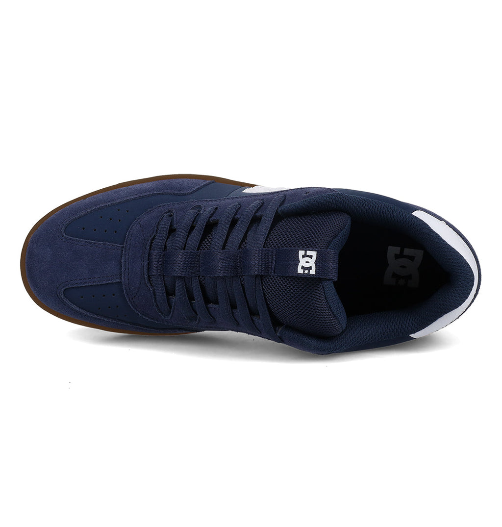 Navy blue Men’s Astrix Shoe by DC Shoes viewed from above, showcasing a lace-up design, ventilated perforations on the toe for breathability, white accents at the heel, and DC branding on the tongue—engineered for superior board control during street skateboarding sessions.