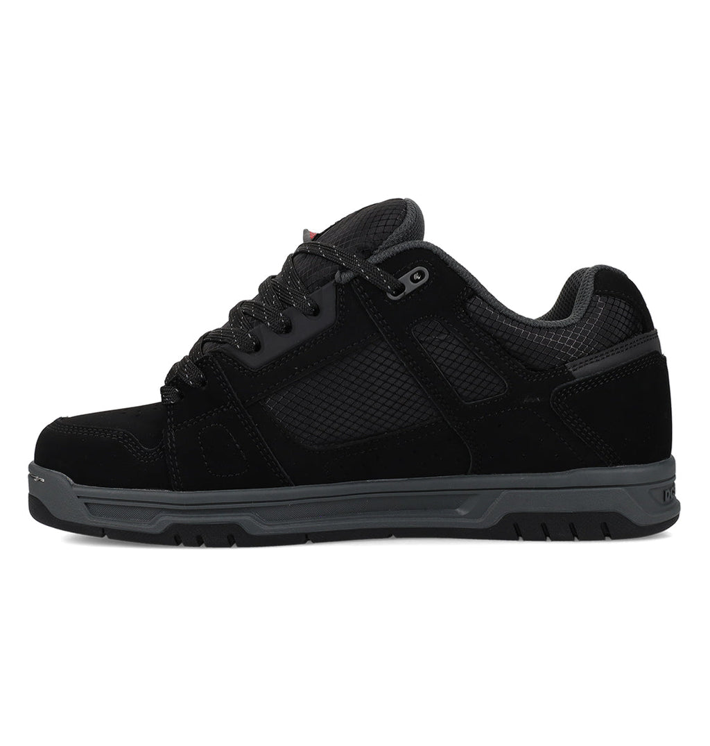 The Men’s Stag Winterized Shoes by DC Shoes are black low-top athletic shoes featuring mesh panels, a textured sole, and black laces. Displayed in a side profile on a white background, they are designed with lightweight cushioning to deliver enhanced comfort with every step.