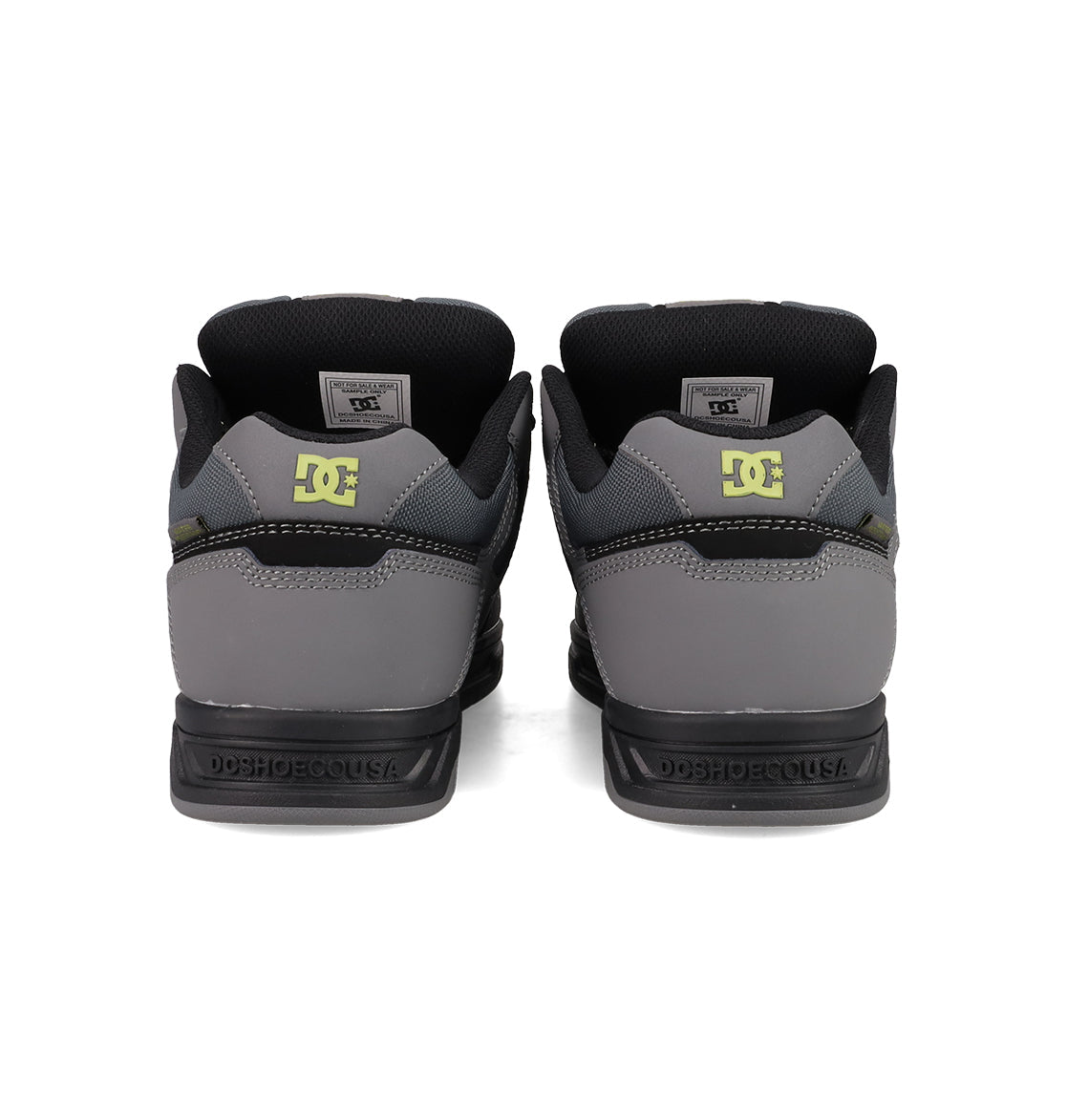 A rear view of Men's Stag Shoes by DC Shoes in grey and black, showing a yellow DC logo on the heels, DCSHOECOUSA on the midsoles, and a skate-inspired durable cupsole.