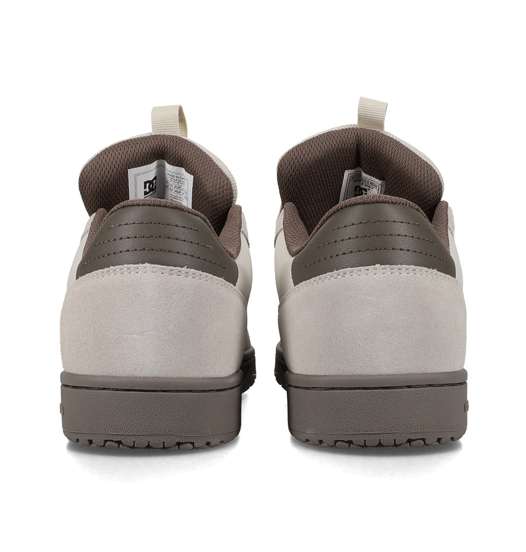 A pair of Men’s Astrix Shoes by DC Shoes in brown and beige are shown from the back, highlighting the heel, outsole, and pull tabs. Designed for board control and street skateboarding, the shoes are placed side by side on a white background.
