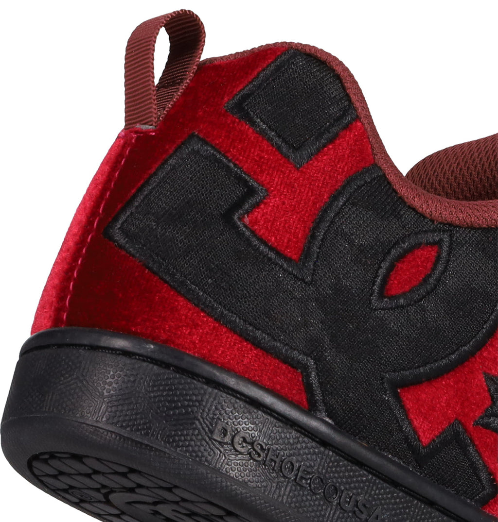 Close-up of the Women’s Court Graffik LE Shoes by DC Shoes, featuring a bold DC logo on a puffy red and black upper, premium materials, textured black sole, and brown pull tab—all in an on-trend colorway.