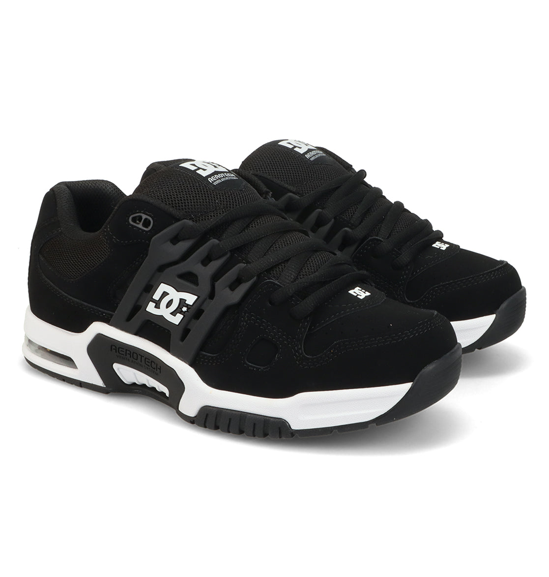 A pair of Men’s AT-2 Shoes by DC Shoes in black, featuring white midsoles, black laces, and the DC logo in white on the side and tongue. These sneakers showcase a chunky silhouette with visible AEROTECH branding on the side, providing cushioned impact and enhanced breathable comfort through advanced AEROTECH ventilation technology.