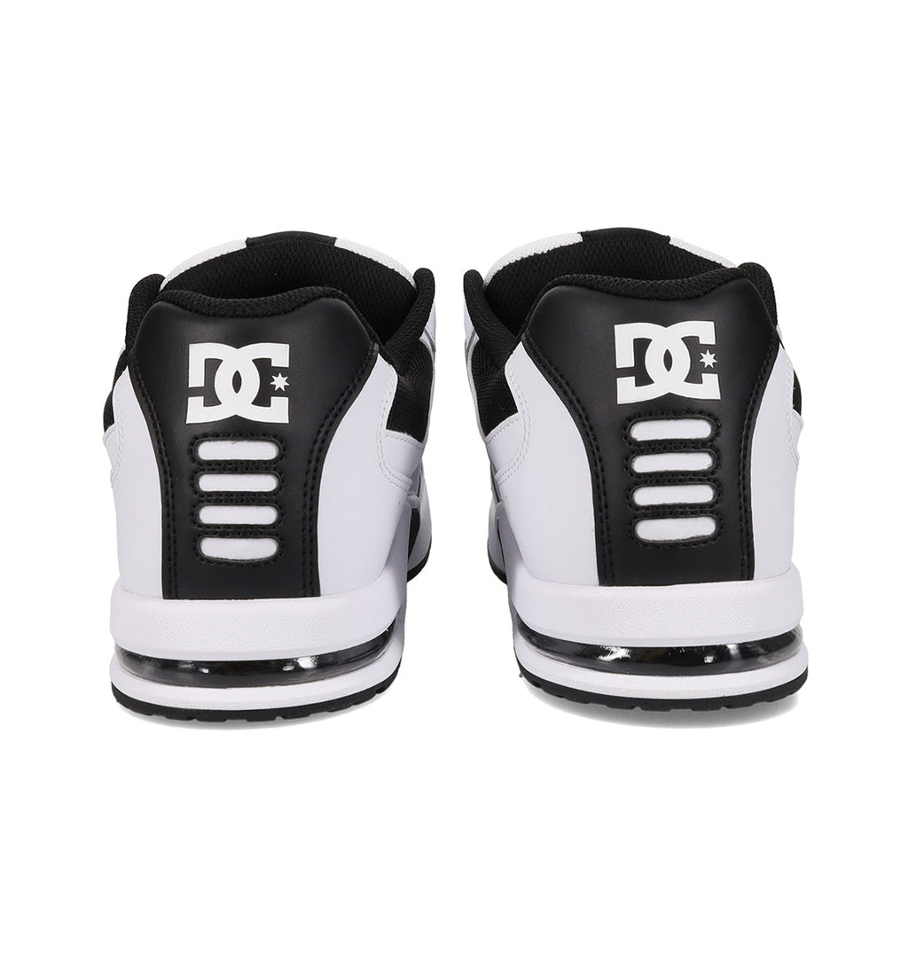 Rear view of a pair of DC Shoes Men’s AT-2 shoes in white and black, featuring the DC logo on the heel counter and horizontal AEROTECH ventilation slots above a cushioned sole.