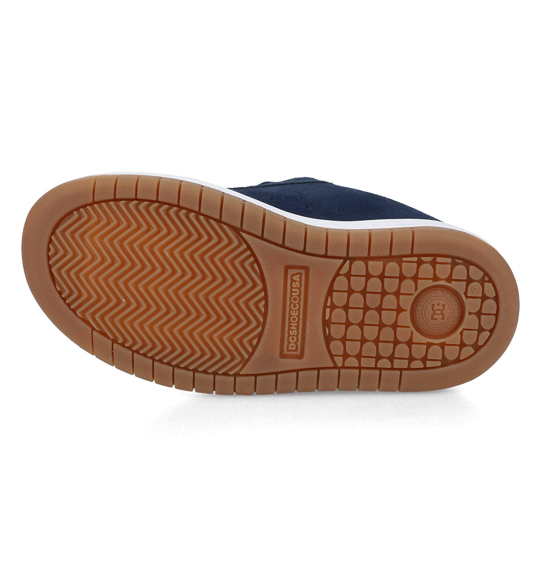 The image shows the gum-colored sole of the DC Shoes Kids’ Court Graffik Shoes, featuring textured grip patterns like herringbone and a circular tread near the heel—a signature detail of these sneakers known for their puffy silhouette.