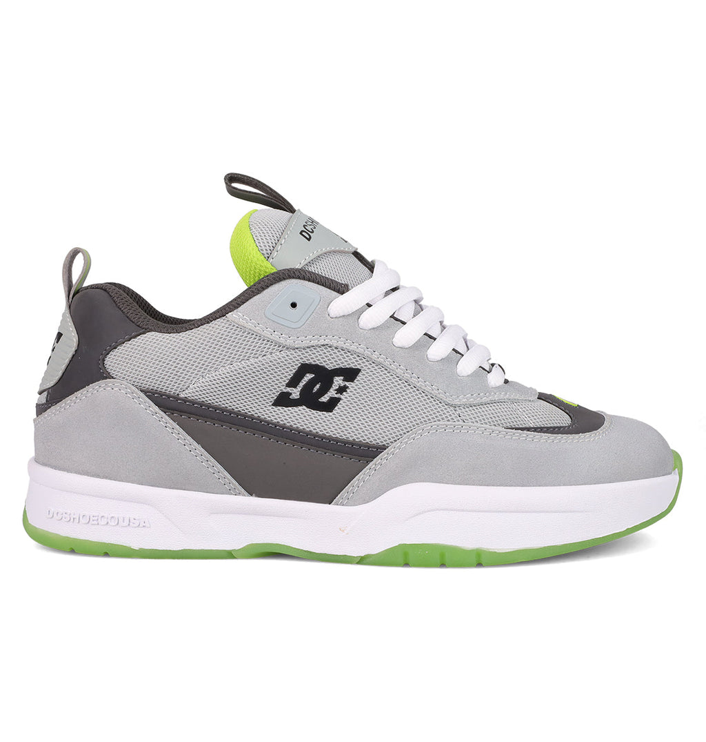 The Men's JS 2 Shoes by DC Shoes feature a gray and black colorway with white laces, a white midsole, neon green details, and a textured green outsole—iconic John Shanahan collection style shown in side profile.
