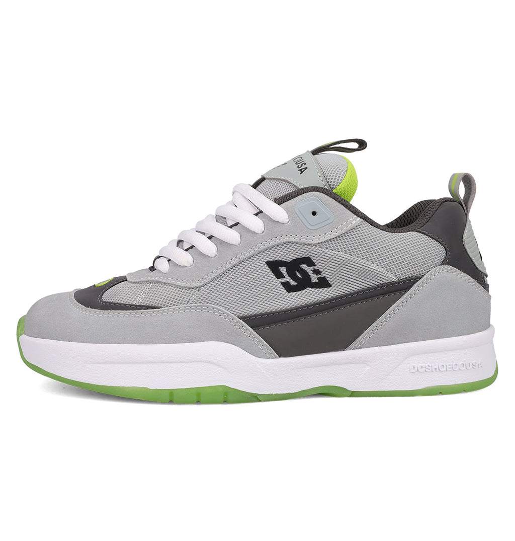 The Men's JS 2 Shoes by DC Shoes are gray and black skate shoes featuring white laces, a white and green sole, green accents, and the DC logo. Shown in side profile on a white background.