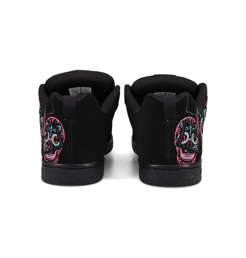 A pair of Women’s Court Graffik Day Of The Dead sneakers by DC Shoes viewed from the back, showcasing vibrant sugar skull designs in pink, teal, and white on the heels—a bold and striking addition to any Día de los Muertos Day of the Dead collection.