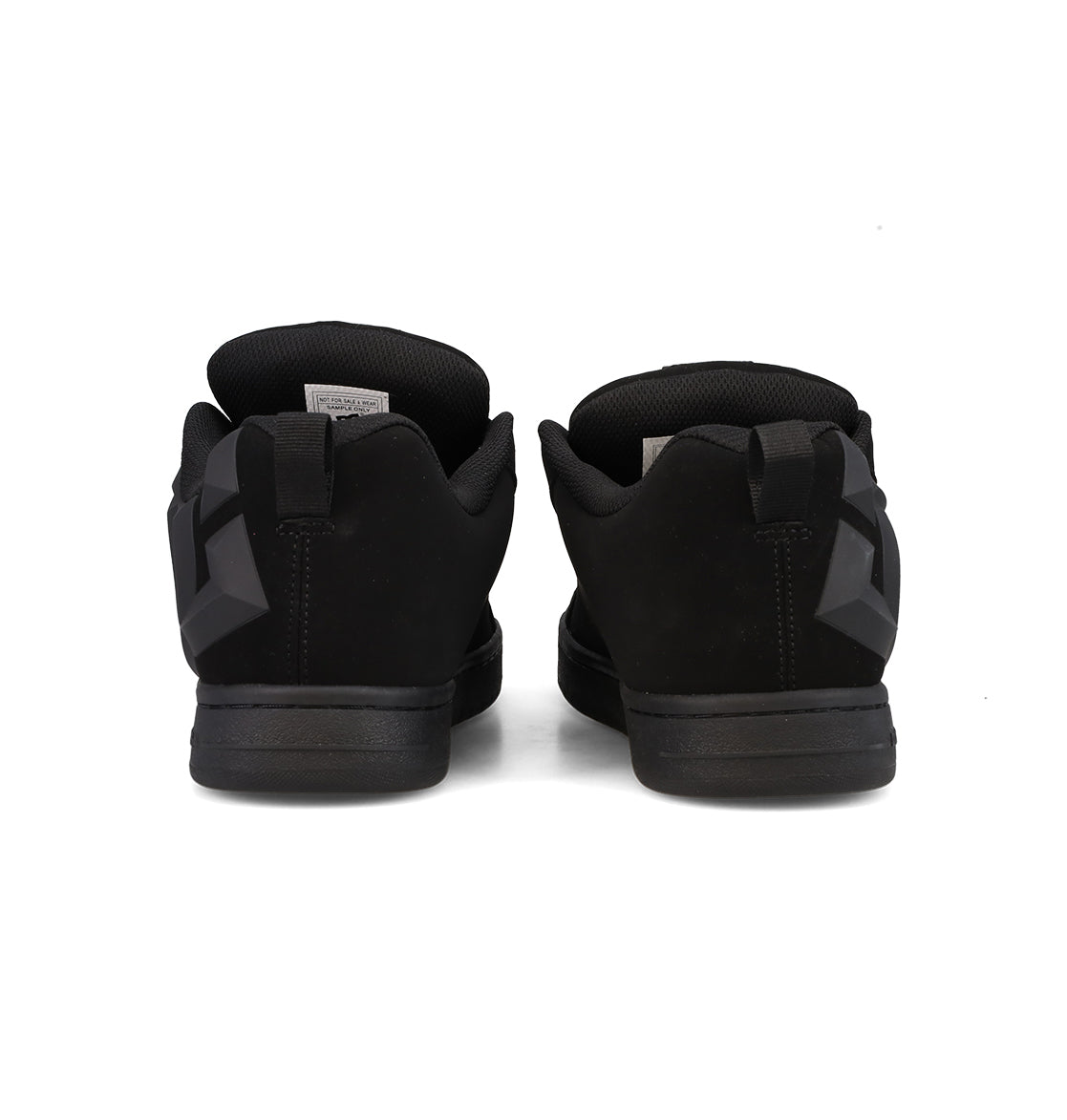 A pair of DC Shoes Men’s Court Graffik Beveled Shoes in black, viewed from the back to highlight the heels, heel tabs, and padded collars. The sneakers showcase a puffy silhouette with a matte finish, subtle geometric accents along the sides, and signature DC branding for an iconic streetwear style.