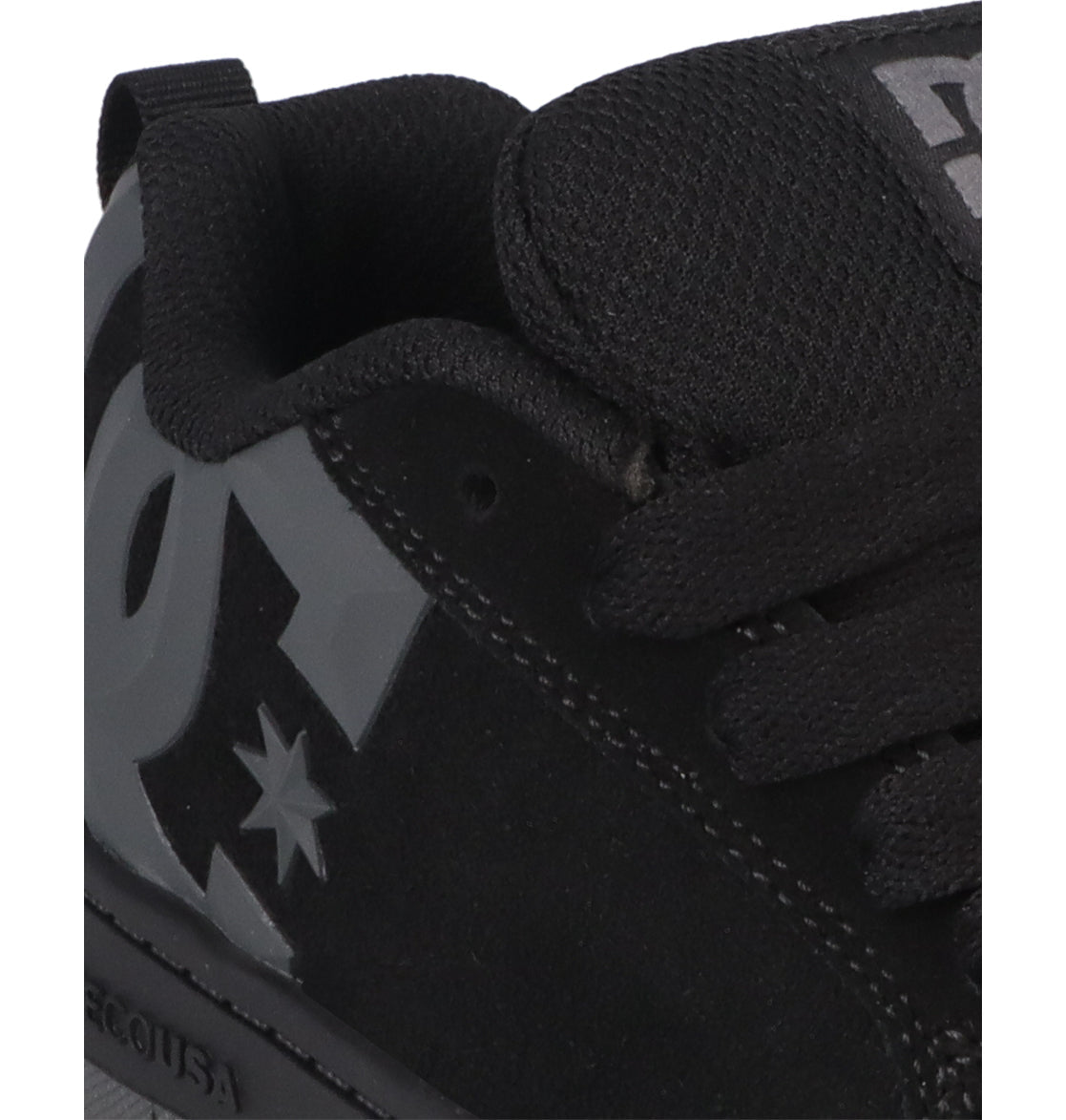 Close-up of the Kids’ Court Graffik Beveled Special Edition Shoes by DC Shoes in black, featuring a prominent gray beveled DC logo and star design on the side for bold branding. The signature puffy silhouette is clearly visible, complemented by black laces and tongue, with part of the sole also shown.